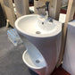 white ceramic wudu wash basin on a grey floor